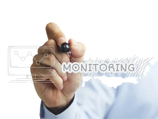 a person hand holding pen with monitoring text written